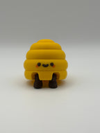 Yellow beehive fidget clicker with a keyring attachment, a brown smiley face, and brown articulated legs. 