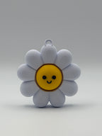 White flower-shaped object with a yellow center and smiley face on a gray background
