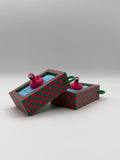 Two pink flamingo in a blue pool fidget clickers with a green keychain and textured pink and green external base.