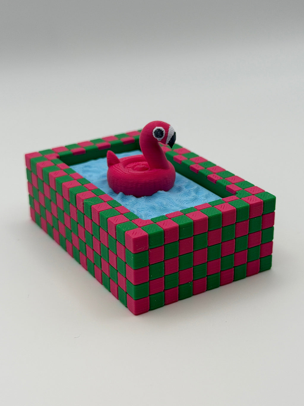A pink flamingo in a blue pool fidget clickers with a green keychain and textured pink and green external base.