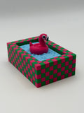 A pink flamingo in a blue pool fidget clickers with a green keychain and textured pink and green external base.