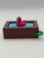 A pink flamingo in a blue pool fidget clickers with a green keychain and textured pink and green external base.