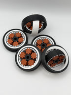Five gyro spinning fidget toys. A black exterior layer, followed by a white layer, followed by another black layer that spins. 5 bronze coloured star shape wheels wrapped around a black star shape cog that spins the bronze wheels. 