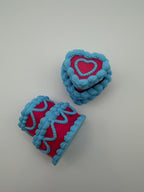 Two pink and blue layered cake fidget clickers.