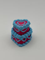 A pink and blue layered cake fidget clicker.