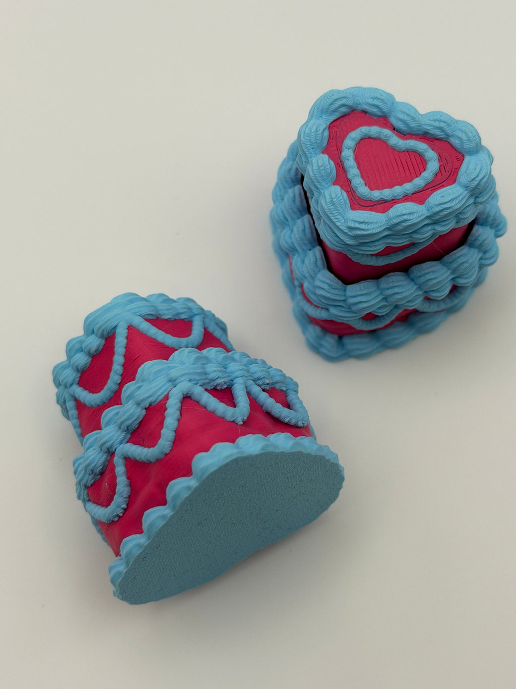 Two pink and blue layered cake fidget clickers.