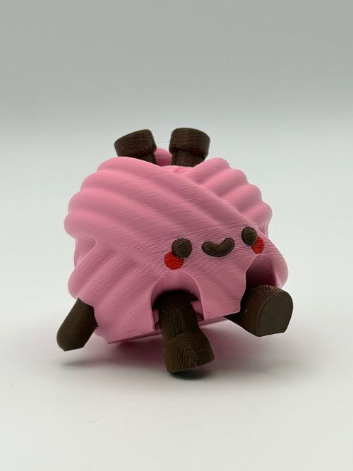 A pink articulated yarn ball fidget clicker with brown feet, one brown hand, and two brown needles in the head.