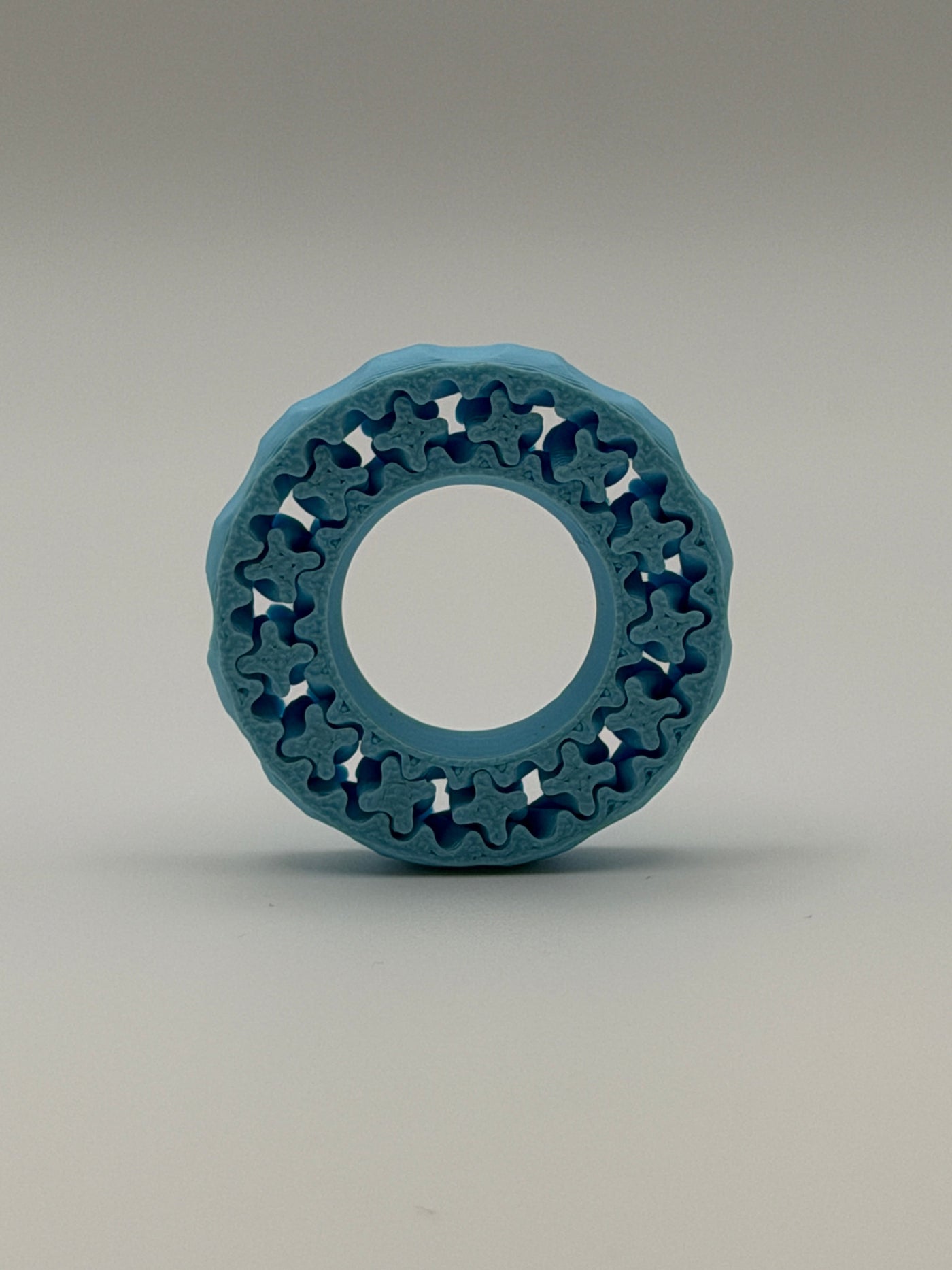 Blue circular ring with a textured surface on a gray background