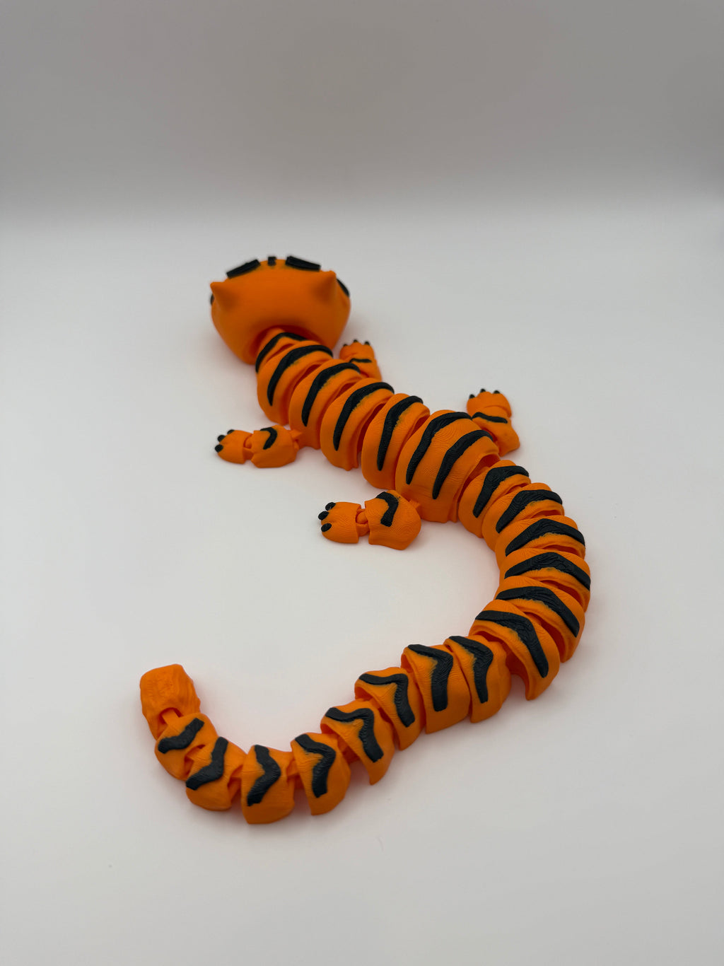 Large orange articulated tiger with black stripes. 