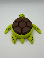 A green and brown shelled fidget clicker turtle.