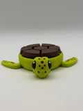 A green and brown shelled fidget clicker turtle.