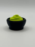 Green wasabi fidget clicker in a black bowl.