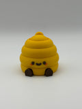 Yellow beehive fidget clicker with a keyring attachment, a brown smiley face, and brown articulated legs. 