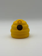 Yellow beehive fidget clicker with a keyring attachment, a brown smiley face, and brown articulated legs. 