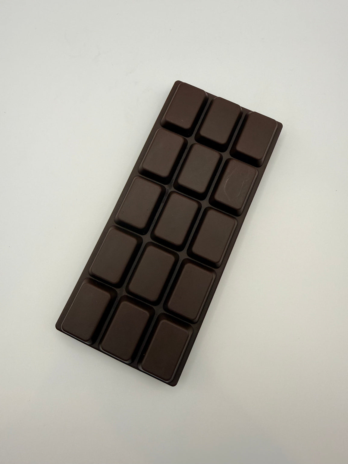 Dark chocolate bar squish toy on a light gray background