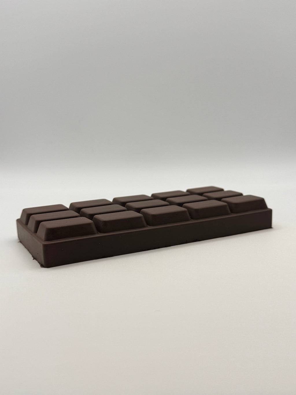 Dark chocolate bar squish toy on a white background