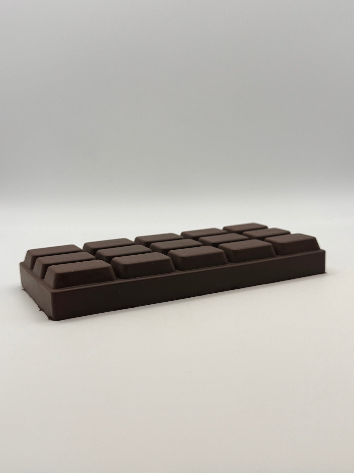 Dark chocolate bar squish toy on a white background