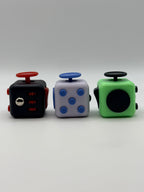 Three fidget cubes in different colors on a white background