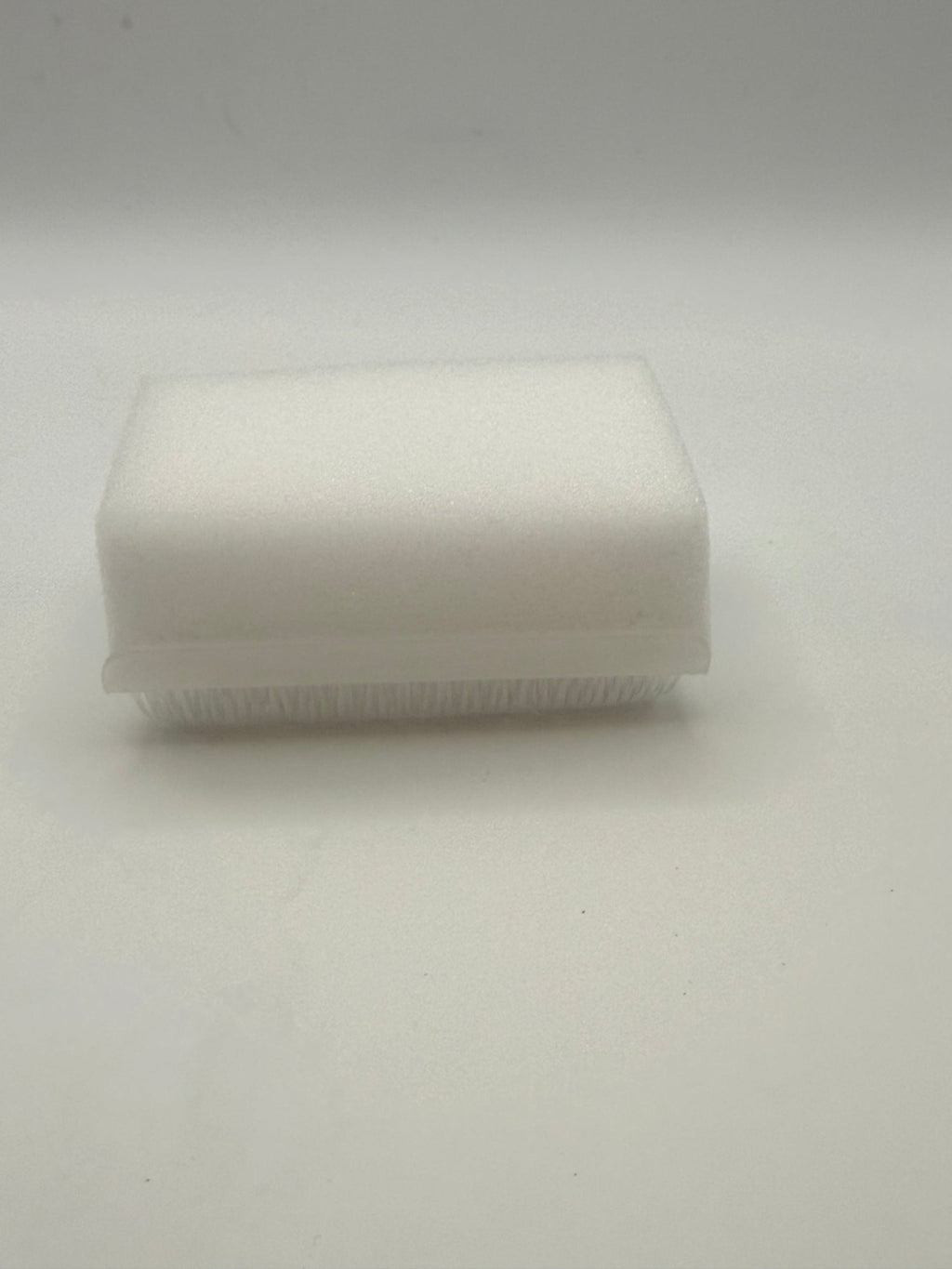 Rectangular white silicone wash brush with sponge.