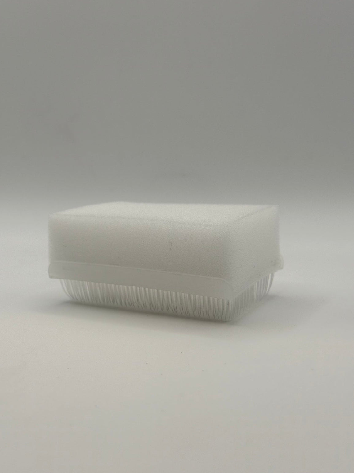 Rectangular white silicone wash brush with sponge.
