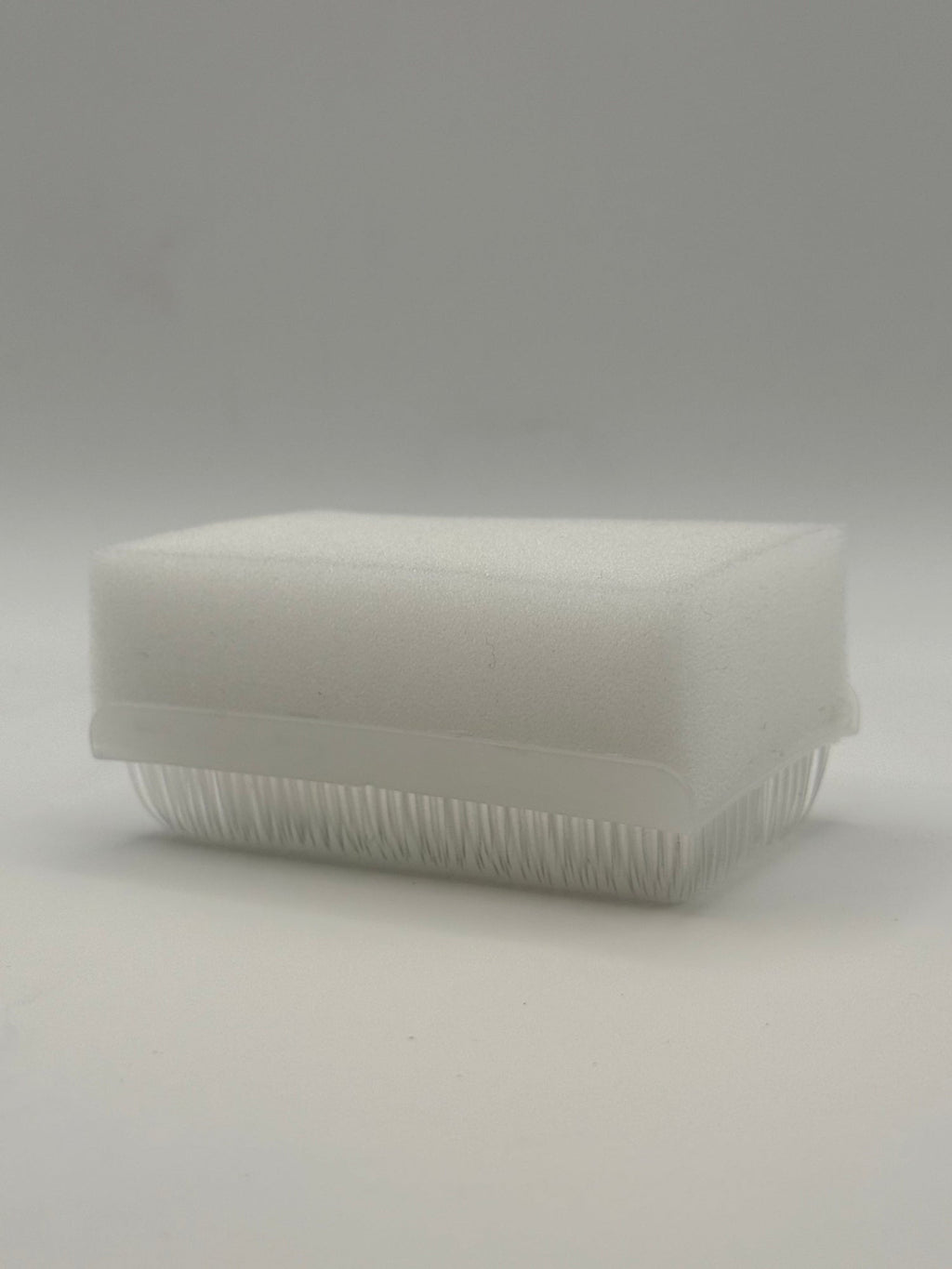 Rectangular white silicone wash brush with sponge.