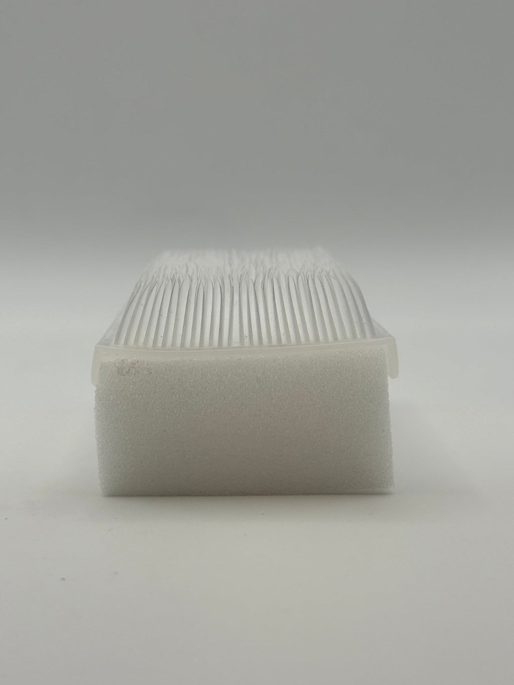 Rectangular white silicone wash brush with sponge.