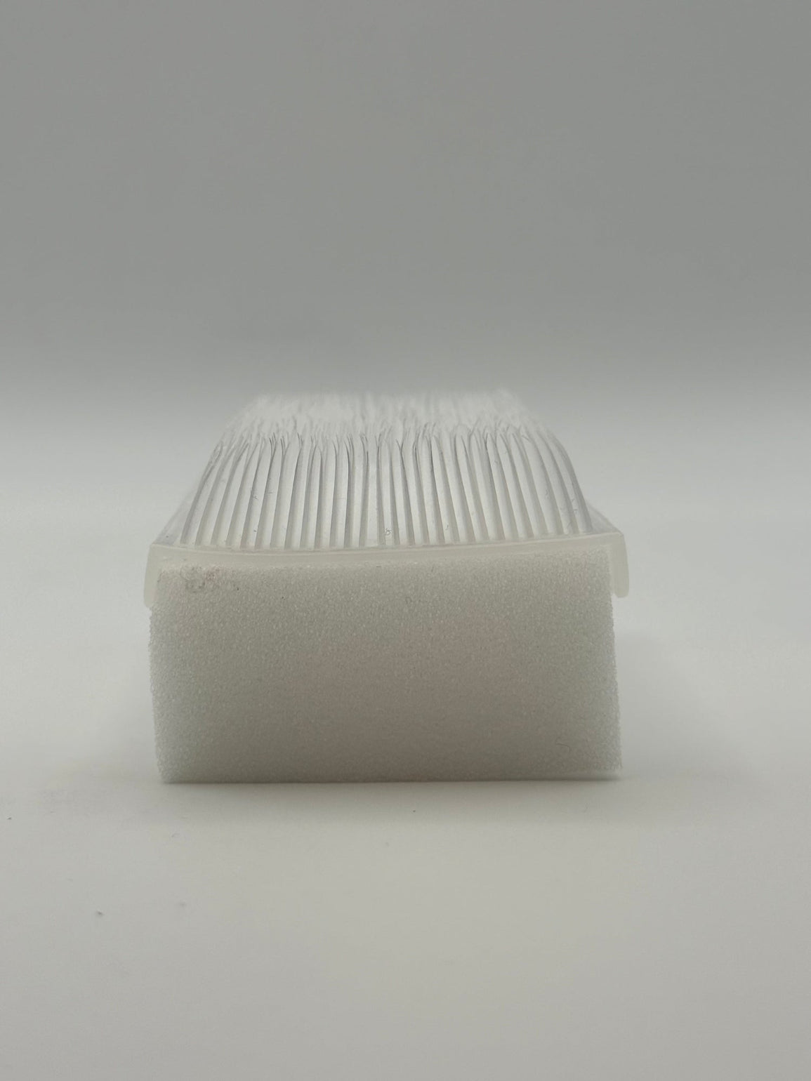 Rectangular white silicone wash brush with sponge.