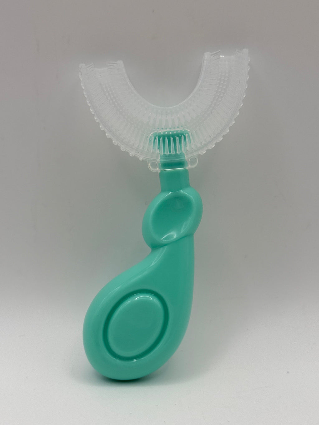 Green U-shaped sensory toothbrush on a white background.