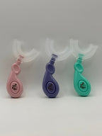 3 U-shaped sensory toothbrushes. Green, purple and pink on a white background.