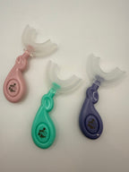 3 U-shaped sensory toothbrushes. Green, purple and pink on a white background.