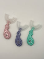 3 U-shaped sensory toothbrushes. Green, purple and pink on a white background.