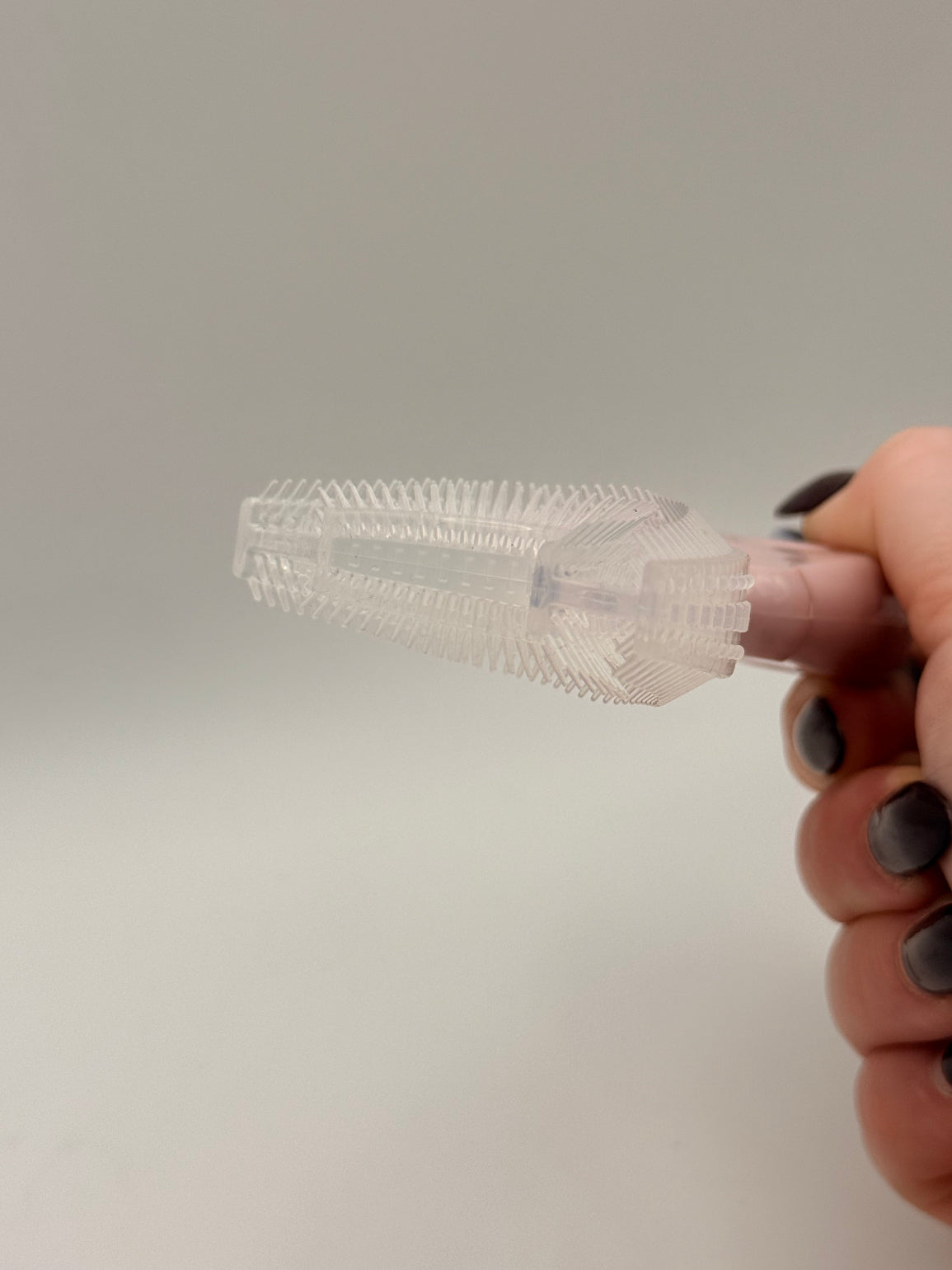 Pink U-shaped sensory toothbrush on a white background.