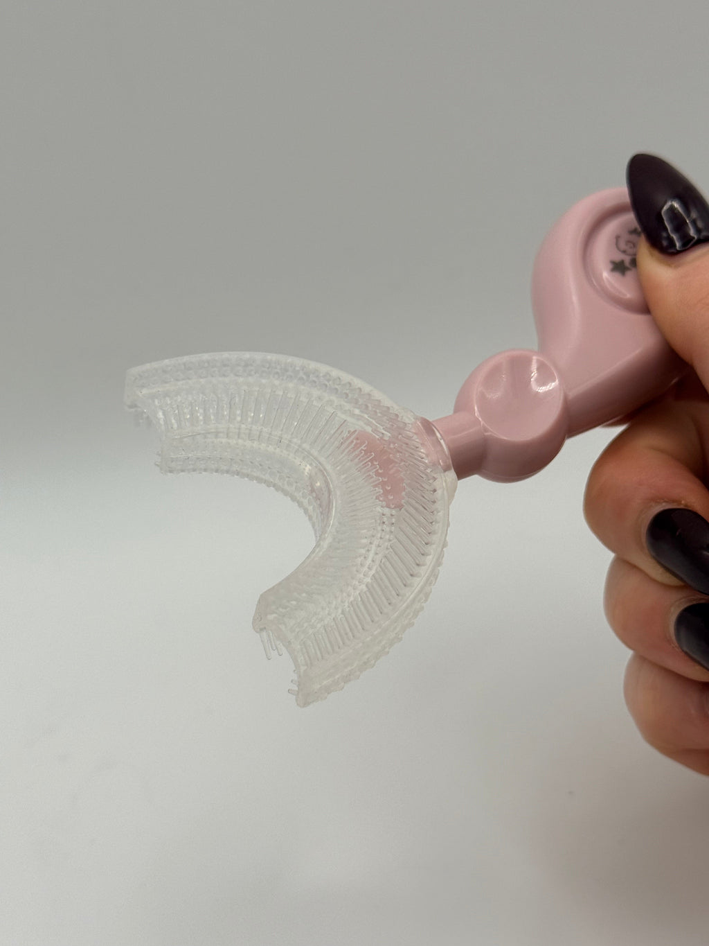 Pink U-shaped sensory toothbrush on a white background.